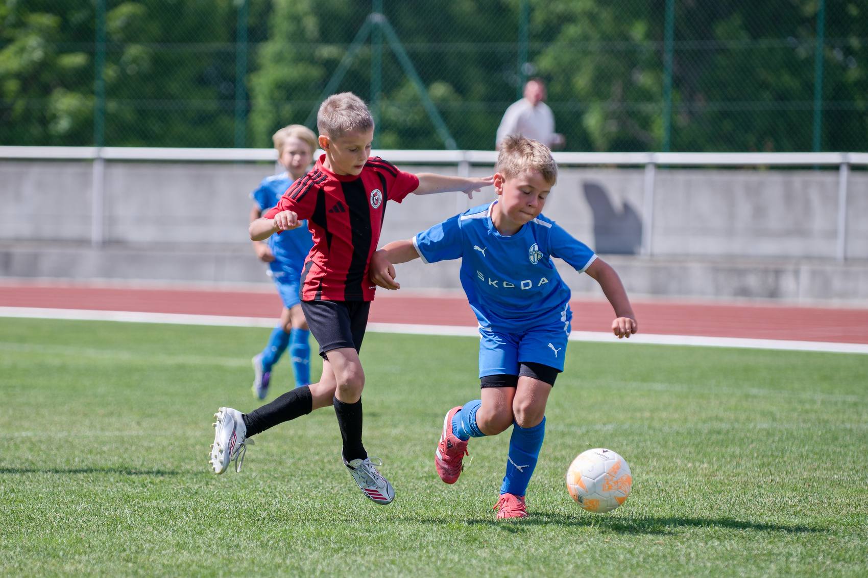 Souboj mladých fotbalistů o míč uprostřed hřiště